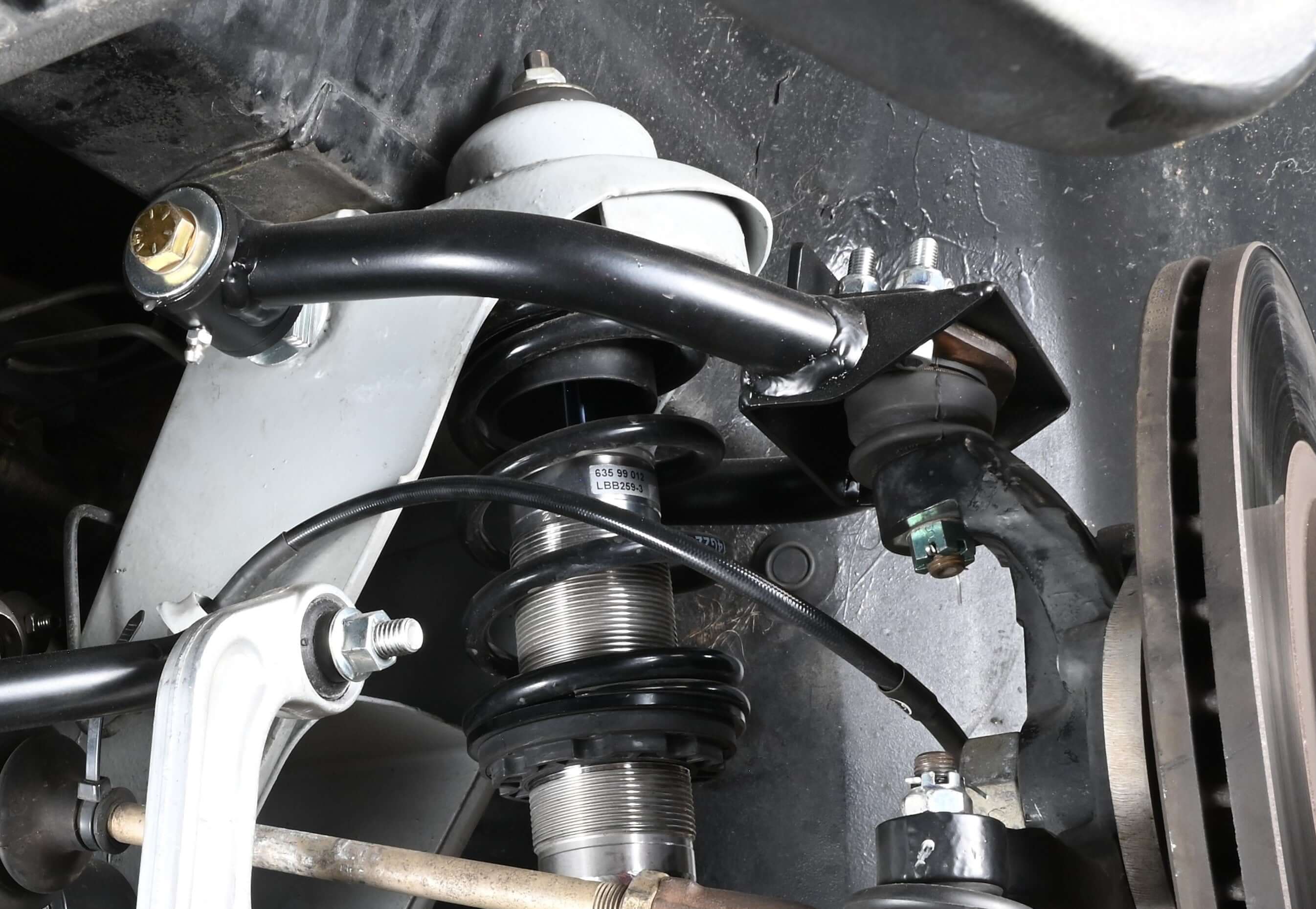 Close-up of SICArm Adjustable Tubular Upper Control Arm installed, showcasing durability and maintenance features for Delorean.